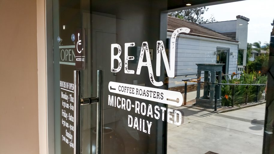 Coffee Shop Door with a Window Decal That Says Bean Coffee Roasters Micro-Roasted Daily