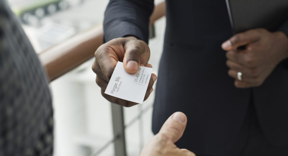 Torso of a Man in a Dark Suit Offering His Business Card